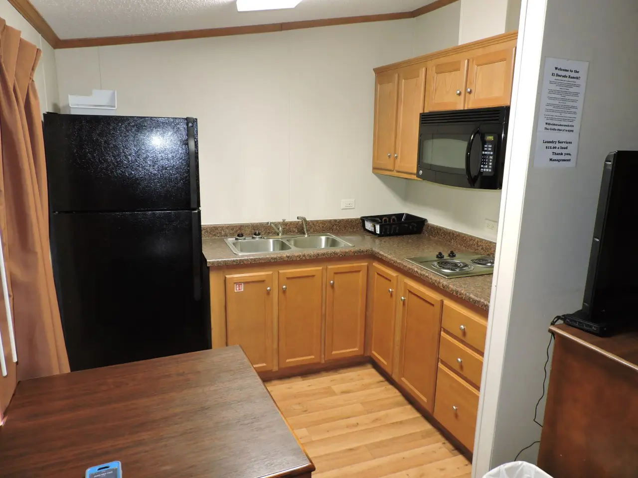 A kitchen with wooden cabinets and black appliances.