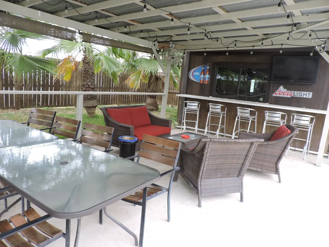 A patio with tables and chairs outside of the house.